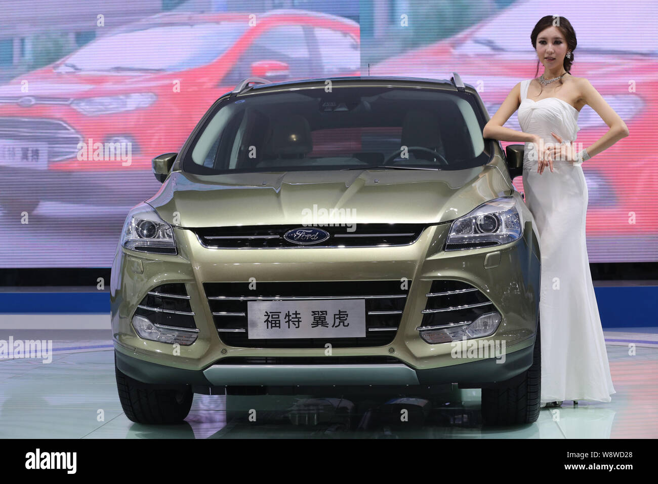 --FILE--un modèle pose avec une Ford Kuga lors d'une auto show à Chongqing, Chine, le 7 juin 2013. Ford Motor Co et ses joint-ventures chinoises vendues 90,7 Banque D'Images