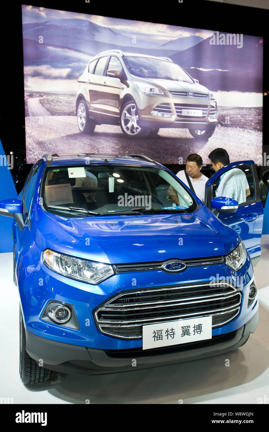 --FILE--visiteurs regardez un SUV Ford EcoSport lors d'une exposition d'automobiles à Beijing, Chine, 9 août 2013. Ford prévoit de lancer 25 nouveaux véhicules Banque D'Images