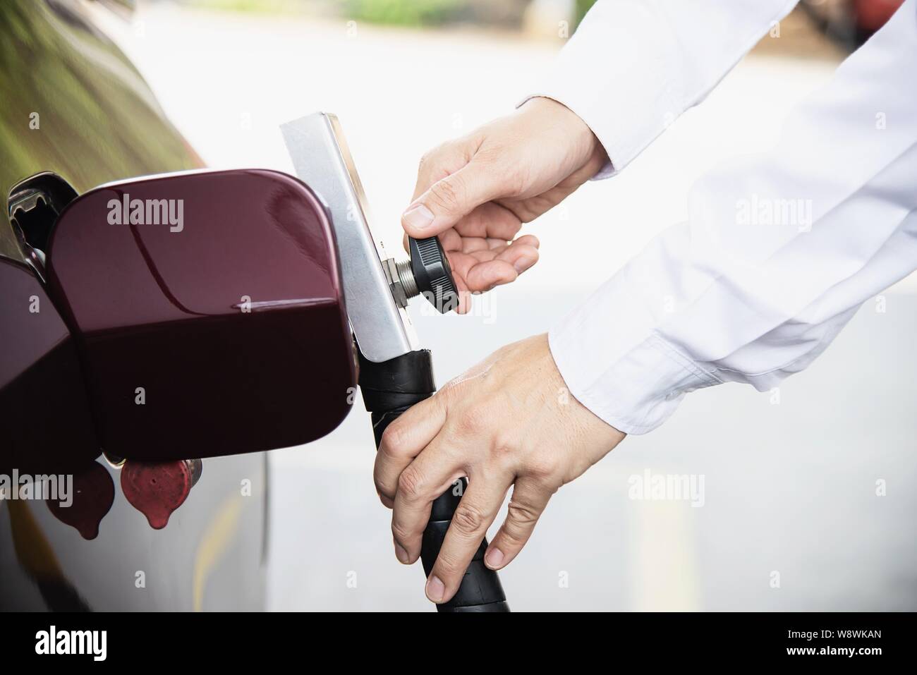 L'homme est de mettre le GNV, Gaz Naturel Véhicule, tête de distributeur une voiture à la station d'essence en Thaïlande Banque D'Images