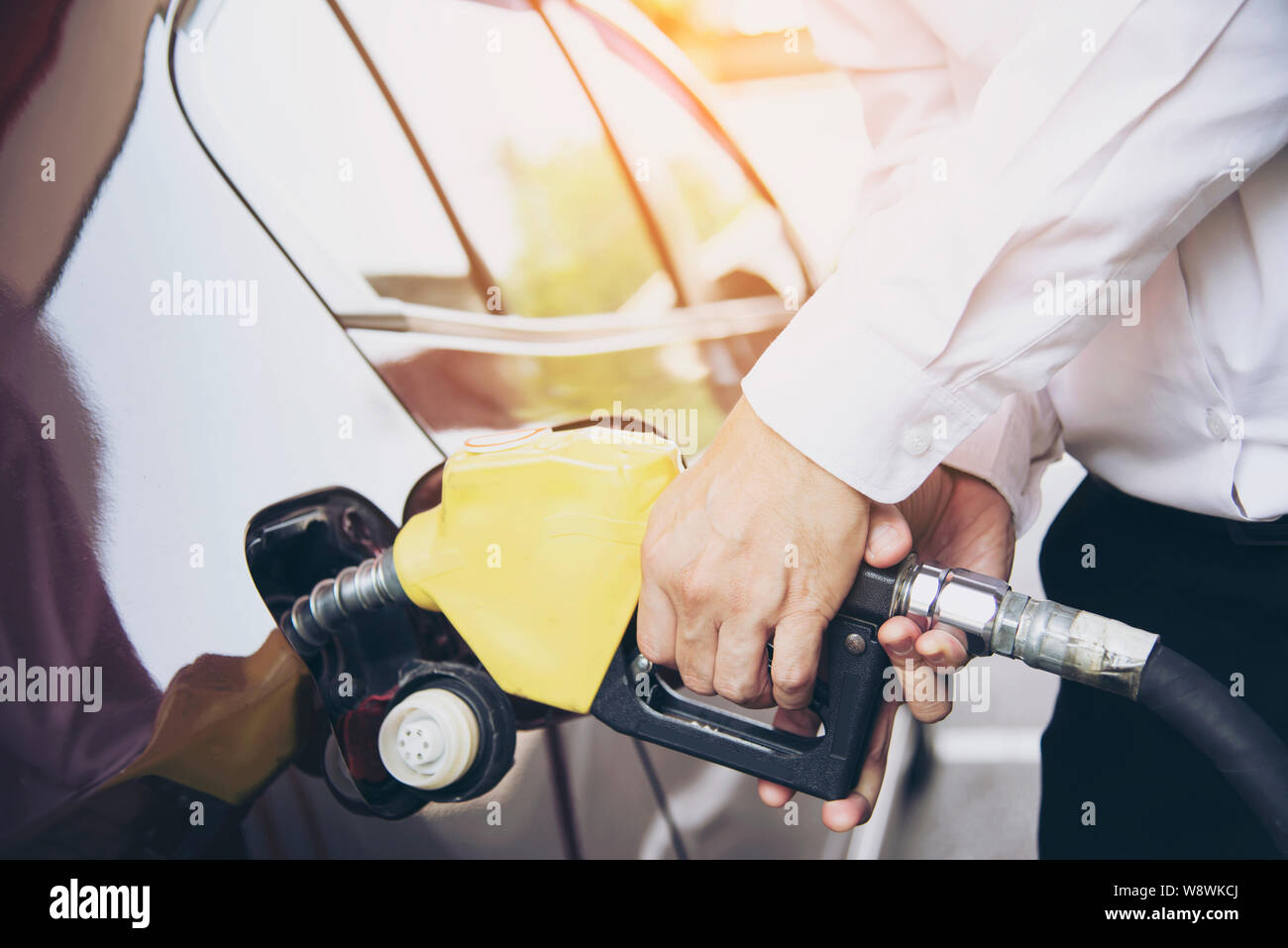 L'homme de mettre l'essence dans sa voiture dans une station essence de la pompe Banque D'Images