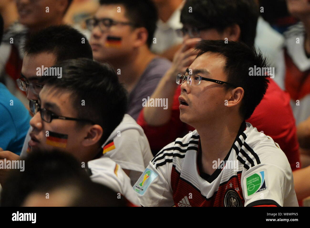 Soccer fans chinois portant des maillots de football de l'équipe nationale Allemagne regarder le match final de la Coupe du Monde de la FIFA 2014 entre l'Allemagne et l'Argentine à un Banque D'Images