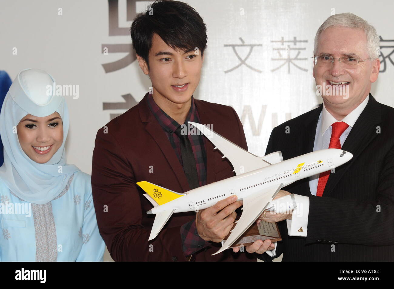 Acteur Wu Chun brunéiens, centre, pose avec Royal Brunei Airlines président Dermot Mannion, droite, et une hôtesse de l'air, au cours d'une cérémonie de signature de bec Banque D'Images