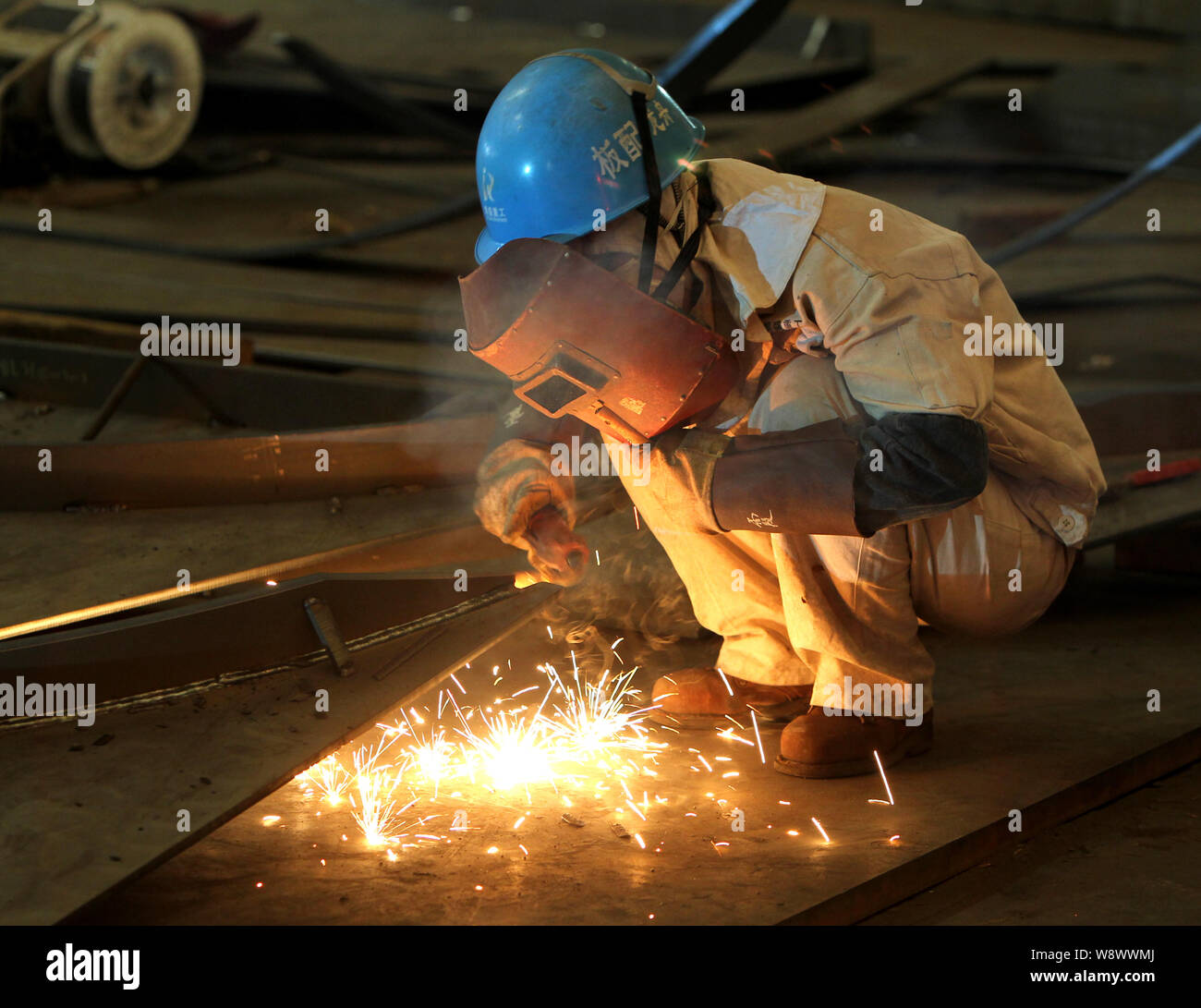 --FILE--un travailleur de soudure des métaux d'une usine à Shanghai, Chine, 11 mars 2014. L'activité manufacturière chinoise renforcée pour une période de cinq mois hi Banque D'Images