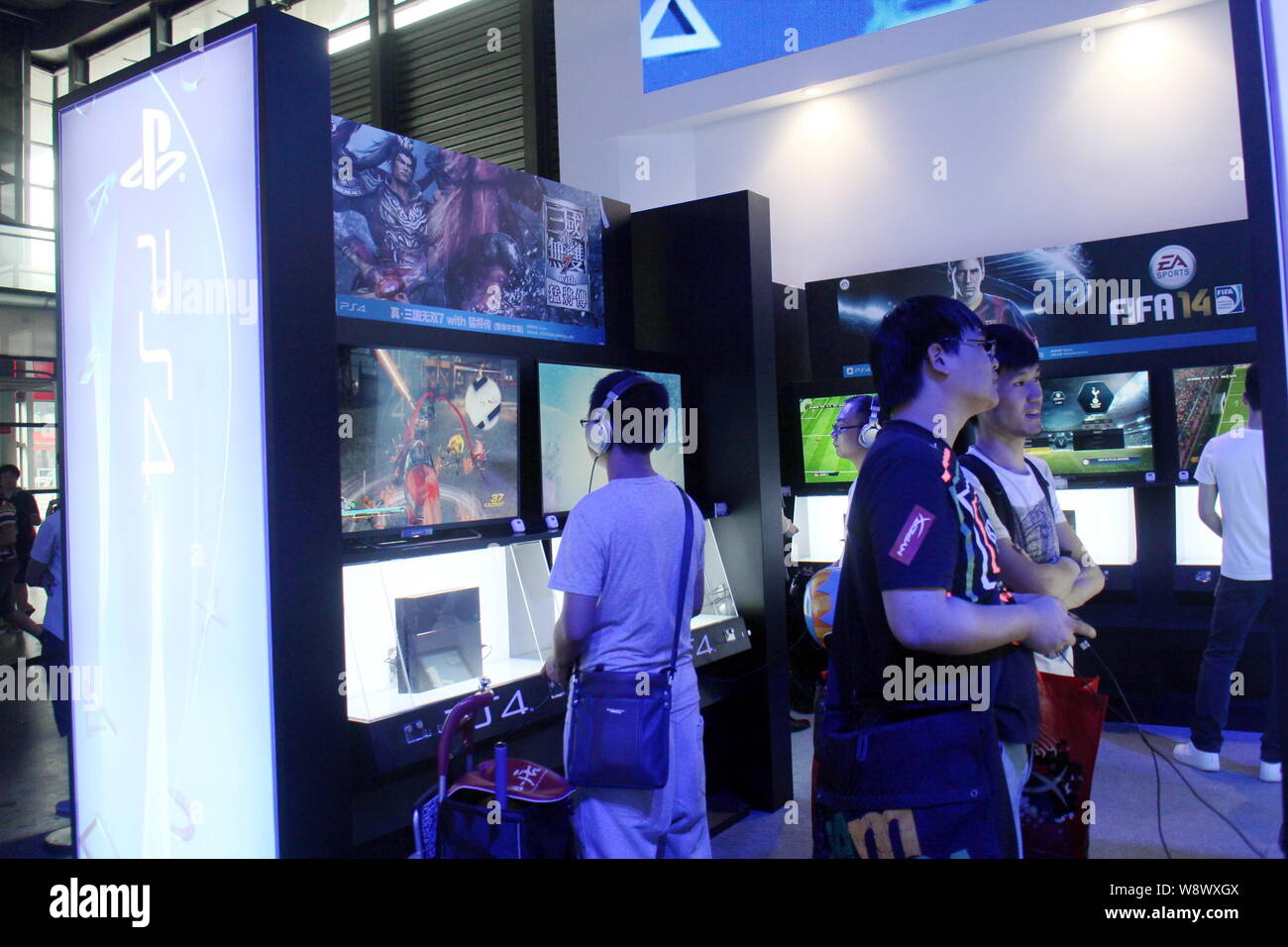--FILE--visiteurs essayer Sony PlayStation 4 (PS4) jeux vidéo durant la 12e China Digital Entertainment Expo, également connu sous le nom de Shan, 2014 ChinaJoy Banque D'Images