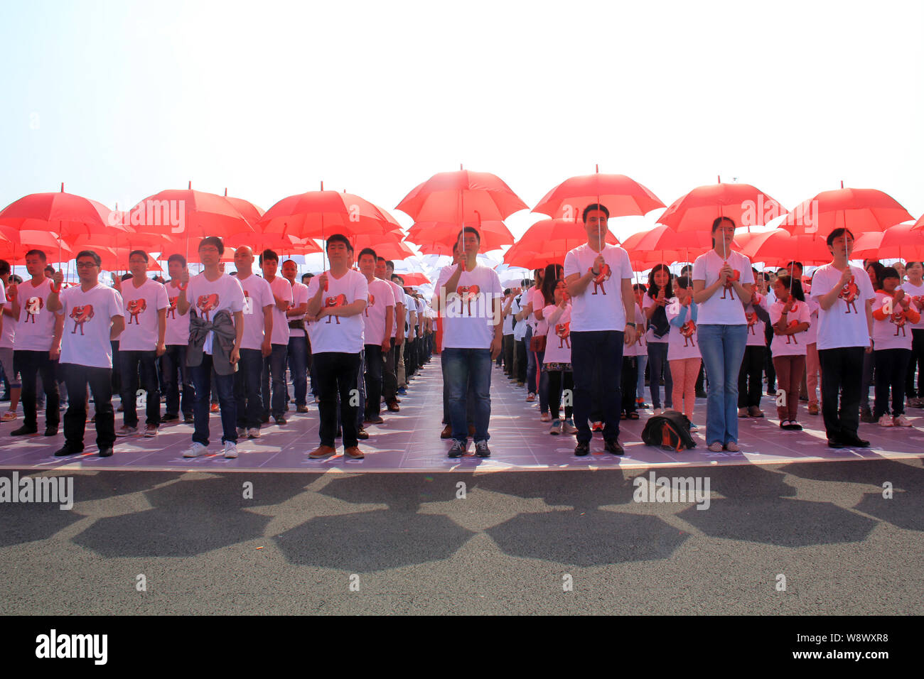 Les employés et les membres de leurs familles des parasols alignés pour créer le plus grand code QR des mondes à l'usine d'embouteillage de Swire Coca-Cola Bever Banque D'Images