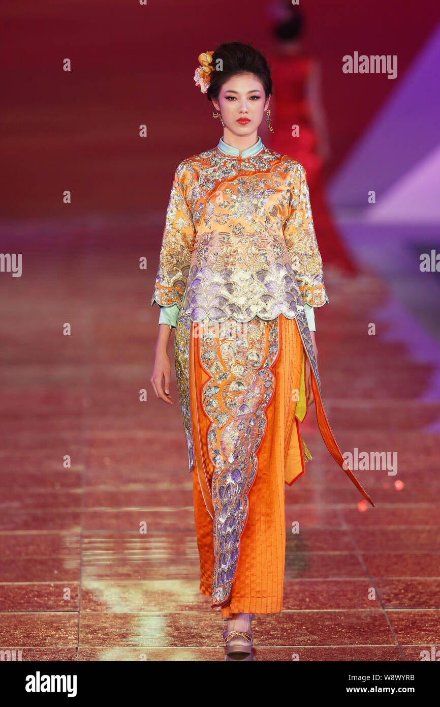 Un modèle affiche une suite nuptiale traditionnelle chinoise robe de mariage de la Rose Studio haute couture par designer Guo Pei lors d'un défilé de mode au cours de la 2014 Sha Banque D'Images