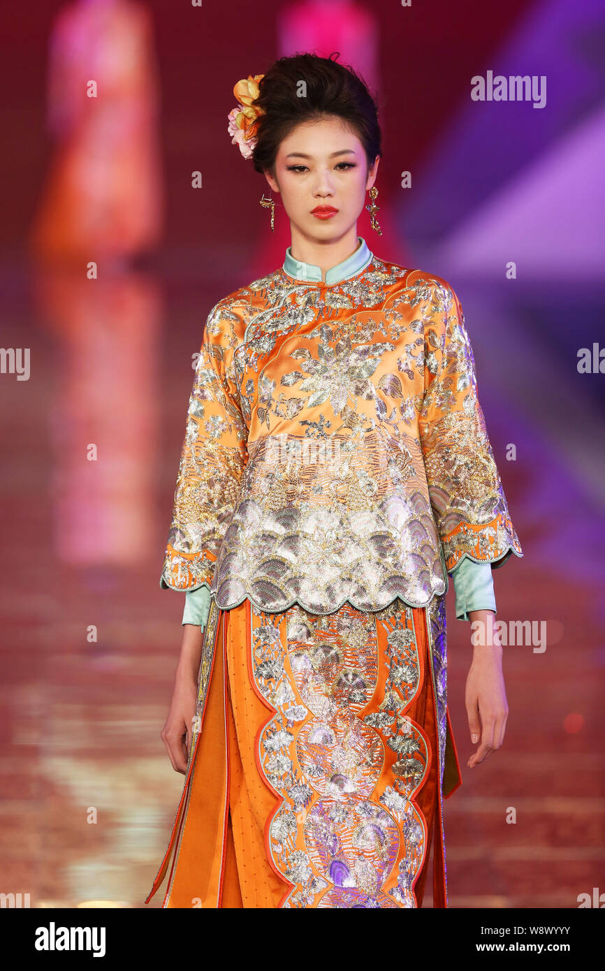 Un modèle affiche une suite nuptiale traditionnelle chinoise robe de mariage de la Rose Studio haute couture par designer Guo Pei lors d'un défilé de mode au cours de la 2014 Sha Banque D'Images