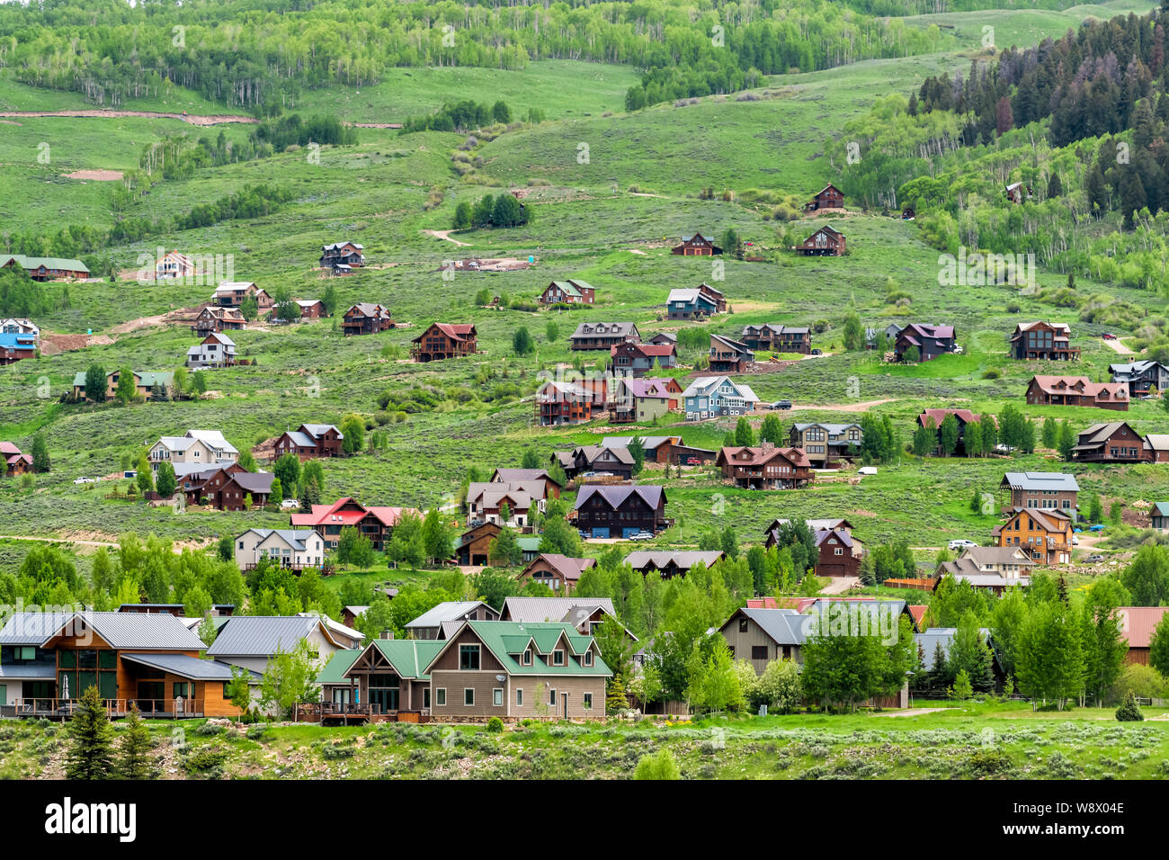 Mount Crested Butte village ville en été avec l'herbe colorés et de nombreuses maisons en bois sur des collines avec des couleurs luxuriantes vert Banque D'Images