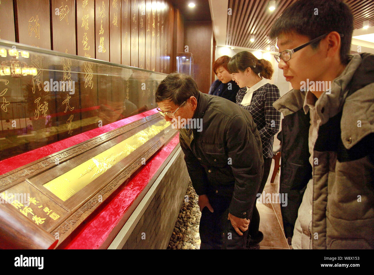 Les visiteurs regarder la réplique d'or de l'ancienne peinture chinoise, demeurant dans la montagnes Fuchun, dans le showroom d'une société d'or dans la région de Hangzhou count Banque D'Images