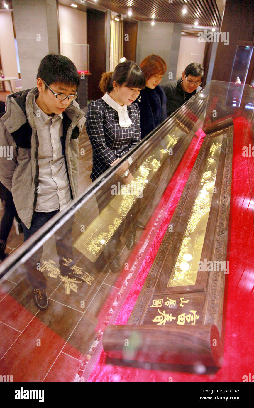 Les visiteurs regarder la réplique d'or de l'ancienne peinture chinoise, demeurant dans la montagnes Fuchun, dans le showroom d'une société d'or dans la région de Hangzhou count Banque D'Images