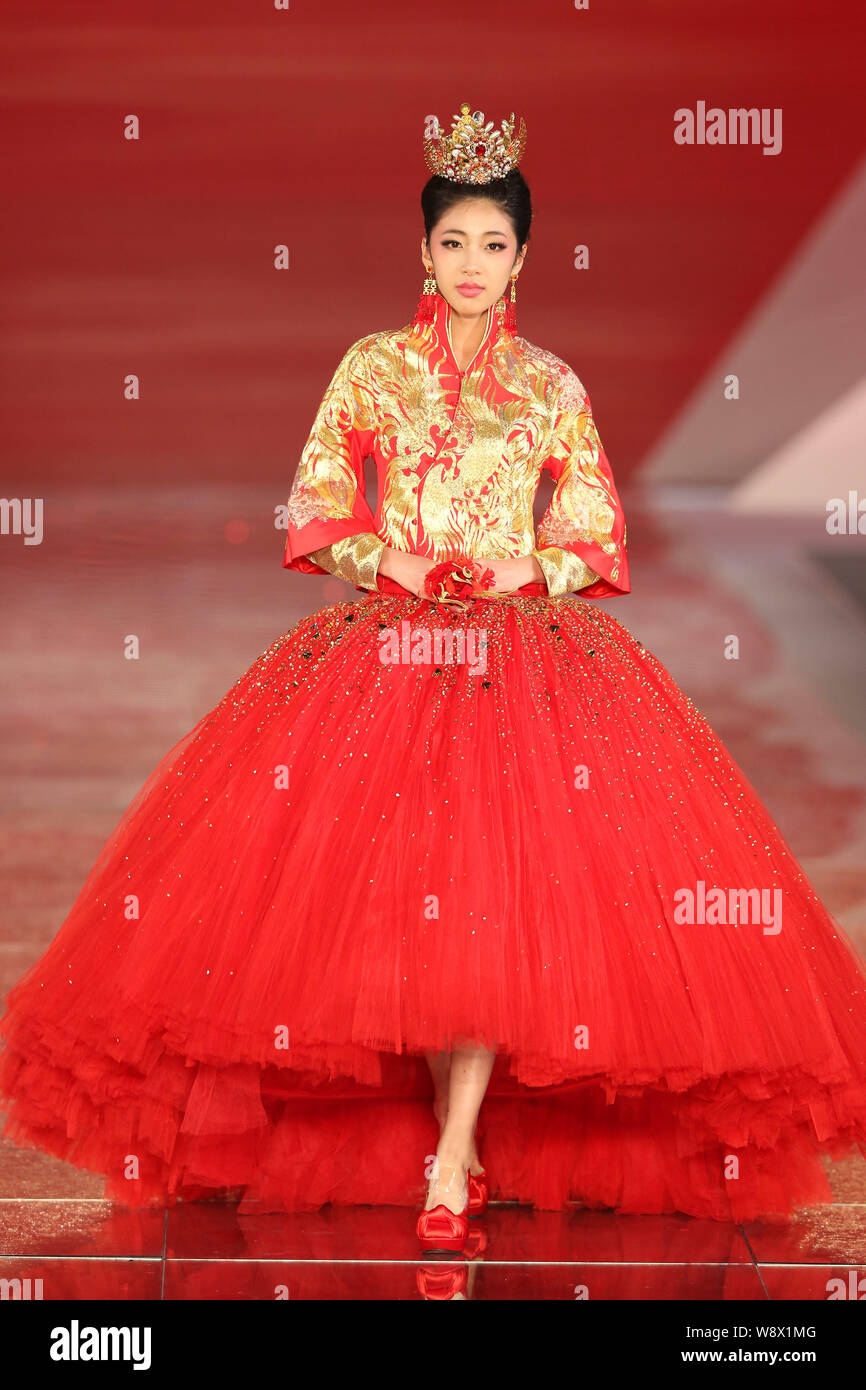 Un modèle affiche une suite nuptiale traditionnelle chinoise robe de mariage de la Rose Studio haute couture par designer Guo Pei lors d'un défilé de mode au cours de la 2014 Sha Banque D'Images