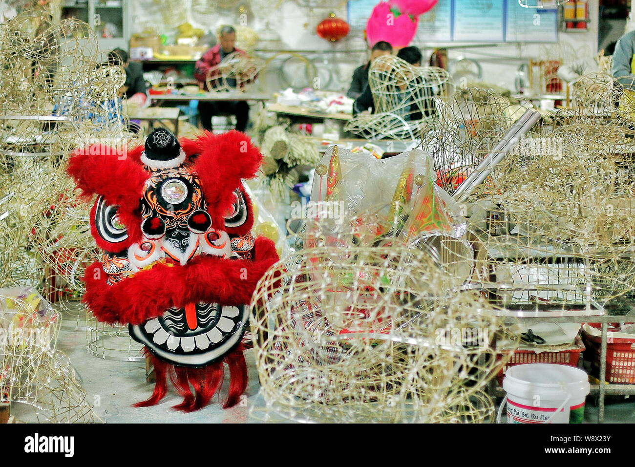 Un lion danse fini est séché entre les armatures en bambou non terminé d'être utilisé pour faire danser les lions dans une usine dans la ville de Guangzhou, Chine du sud' Banque D'Images