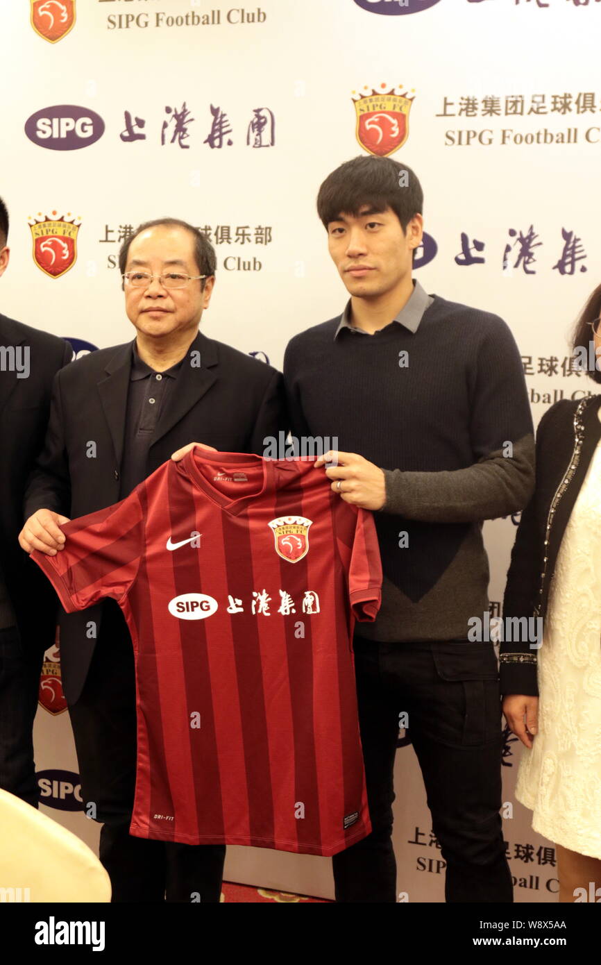 Joueur de football sud-coréen Kim Ju-young, droite, sourire alors qu'il reçoit son uniforme de l'équipe au cours d'une conférence de presse pour annoncer son arrivée EPOP Footba Banque D'Images