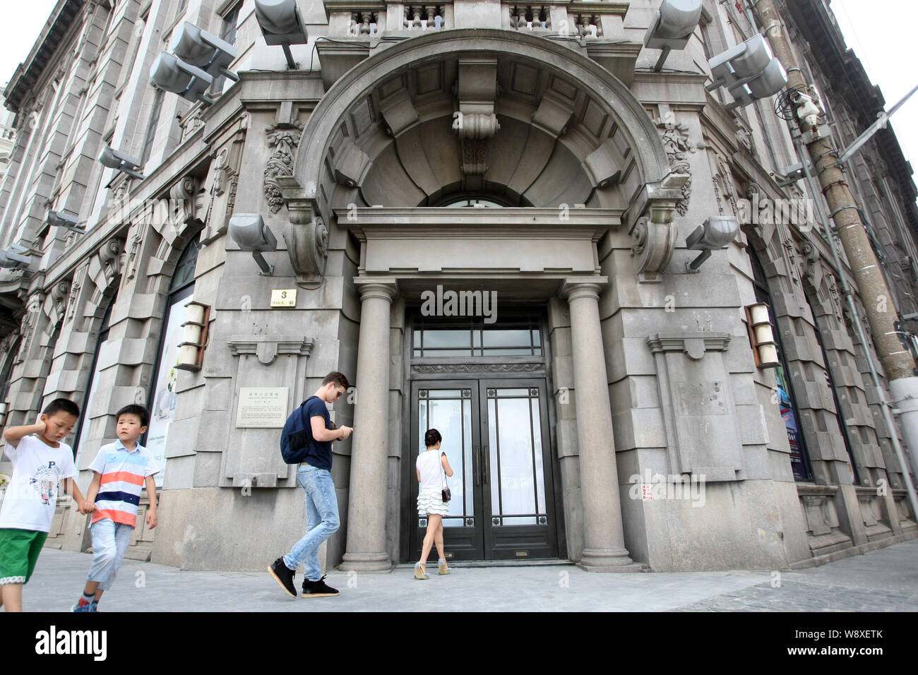 Les piétons passer devant l'ancienne boutique de mode de Giorgio Armani à trois sur le Bund à Shanghai, Chine, le 7 août 2014. Le long du Bund, la famo Banque D'Images