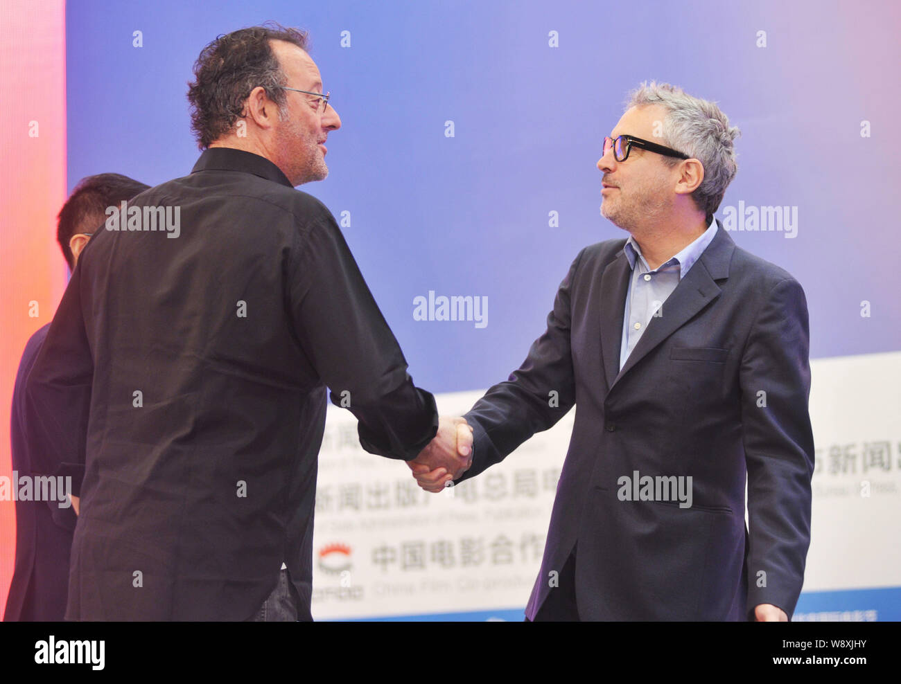 L'acteur français Jean Reno, gauche, serre la main avec le réalisateur mexicain Alfonso Cuaron, droite, au cours de l'Sino-Foreign Film Co-production Forum du 4 Banque D'Images