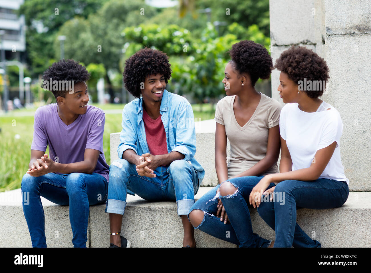 Groupe de jeunes adultes américains africains parler traînant dehors dans l'été en ville Banque D'Images