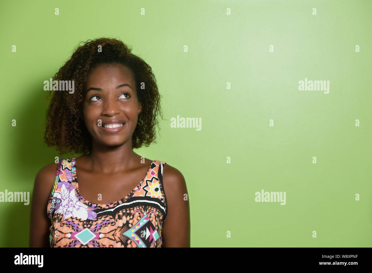 Belle femme afro-américaine à l'horizontale pour une muraille verte Banque D'Images