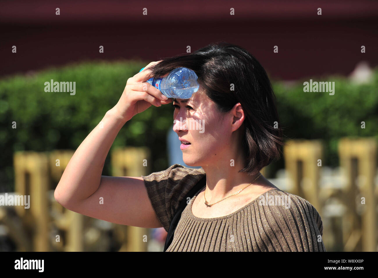 Un piéton shields du soleil de plomb dans une rue de Beijing, Chine, 29 mai 2014. Au moins deux personnes sont mortes de chaleur, Chine Banque D'Images