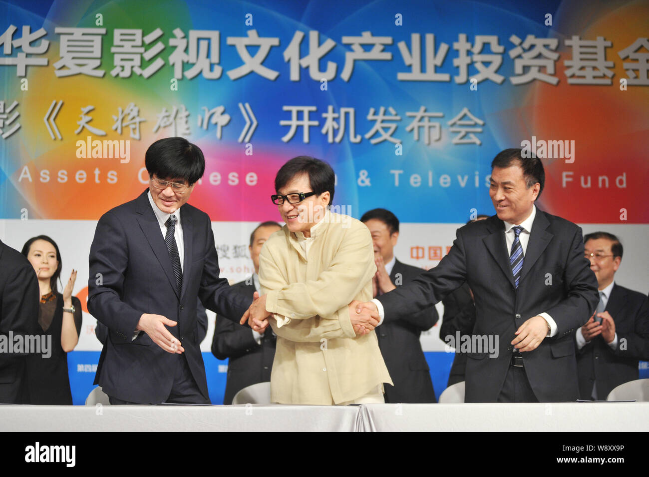 L'acteur de Hong Kong Jackie Chan, l'avant centre, serre la main avec les représentants de groupes d'investissement de film au cours d'une cérémonie de prise de vue pour son nouveau film dans Banque D'Images