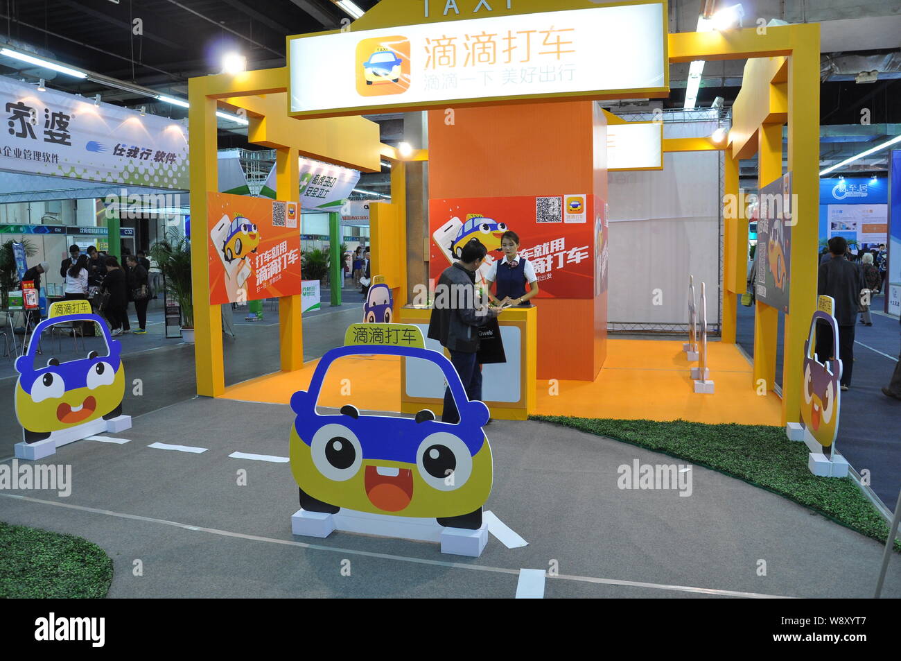 --FILE--Un employé sert un visiteur sur le stand de taxi réservation app Didi Dache de Tencent lors d'une exposition dans la ville de Shenyang, au nord-est de porcelaines Li Banque D'Images