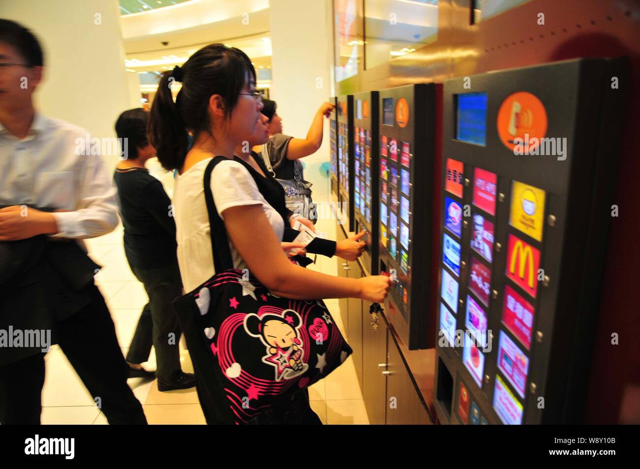Les clients chinois imprimer des coupons en face du coupon printers de Velo à un centre commercial sur la rue commerçante de Wangfujing à Beijing, Chine, le 6 octobre Banque D'Images