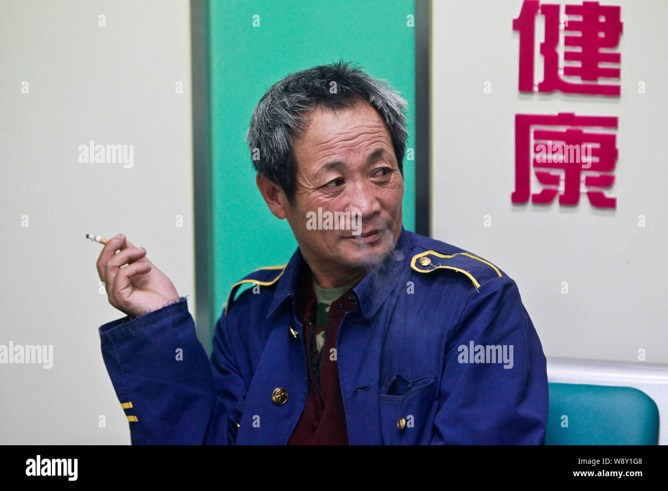 --FILE--un Chinois fume lors d'une station de bus dans la ville de Qingdao, province du Shandong, Chine de l'Est 30 mai 2013. Le chef de l'Organisation mondiale de la Santé Banque D'Images