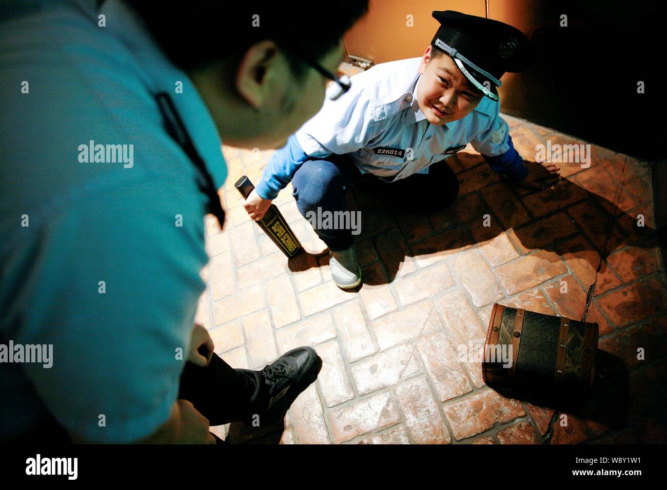 Un jeune garçon vêtu d'un uniforme de policier parle à un membre du personnel du musée pour enfants de professions à Beijing, Chine, 2 octobre 2014. À partir de la médecin Banque D'Images