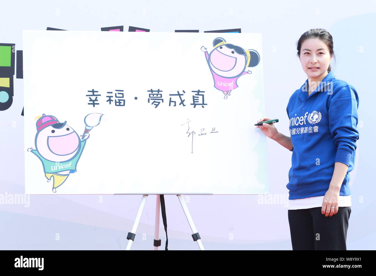 Champion de plongée olympique chinoise Guo Jingjing des autographes sur un conseil à un événement de bienfaisance pour le Comité de Hong Kong pour l'Organisation des Nations Unies pour l'Fun Banque D'Images