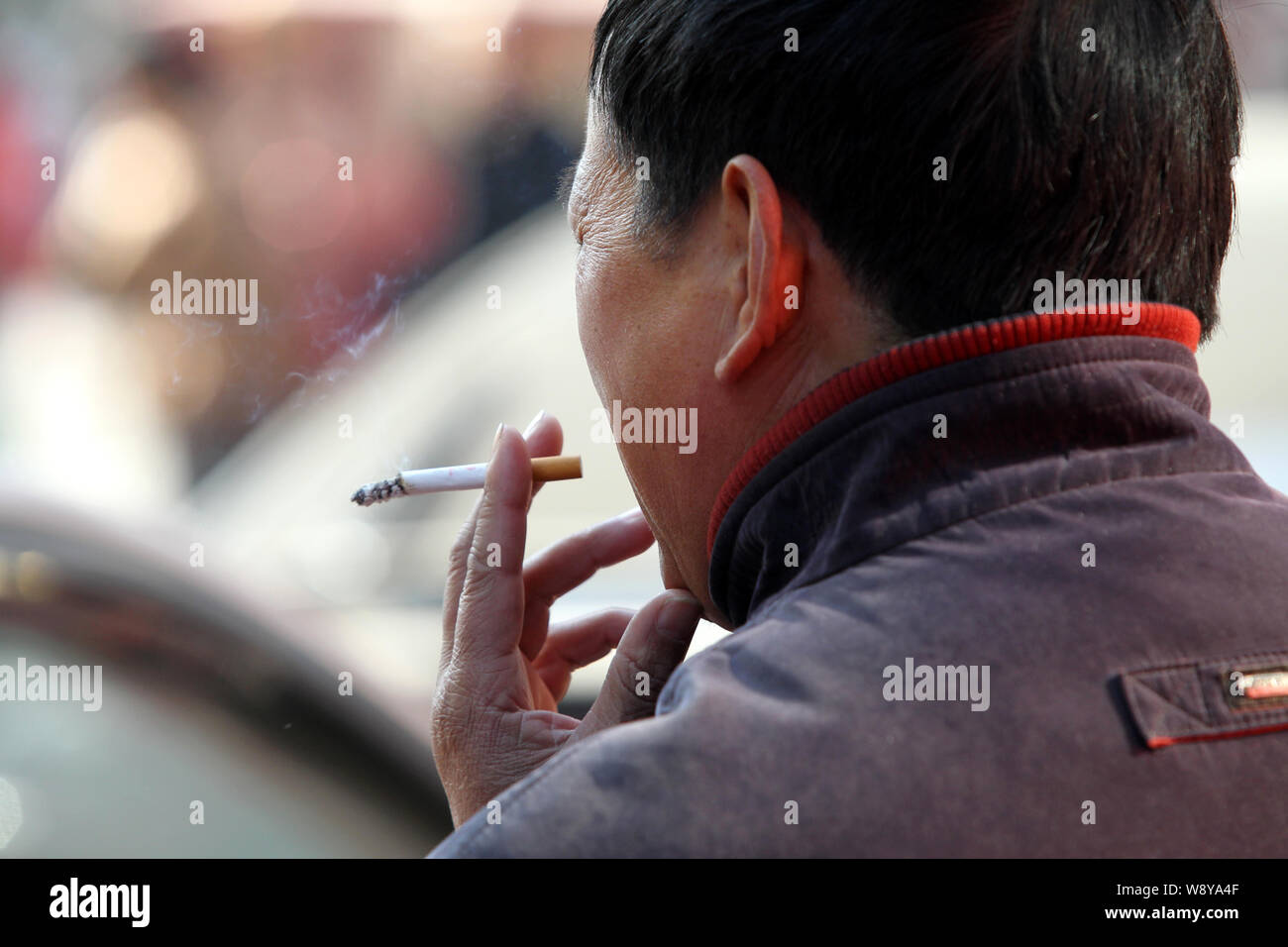 --FILE--un Chinois fume sur une route dans la ville de Nantong, Chine de l'est de la province de Jiangsu, le 30 novembre 2013. Le chef de l'Organisation mondiale de la santé ha Banque D'Images