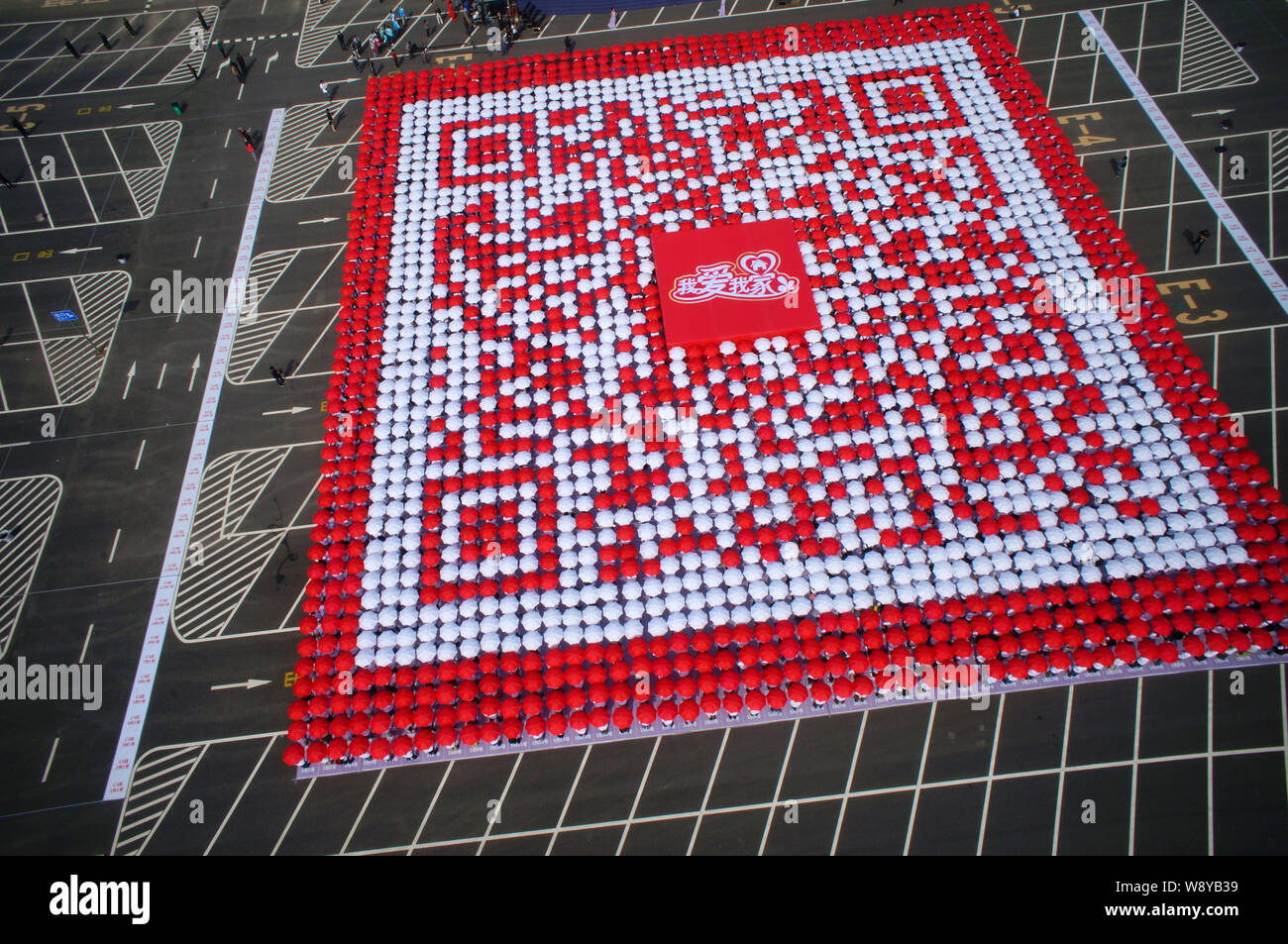 Les employés et les membres de leurs familles des parasols alignés pour créer le plus grand code QR des mondes à l'usine d'embouteillage de Swire Coca-Cola Bever Banque D'Images