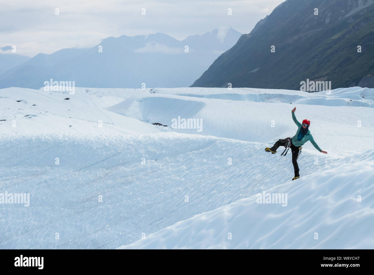 Guide ludique glacier femme debout sur une jambe sur le Glacier Matanuska en Alaska Banque D'Images