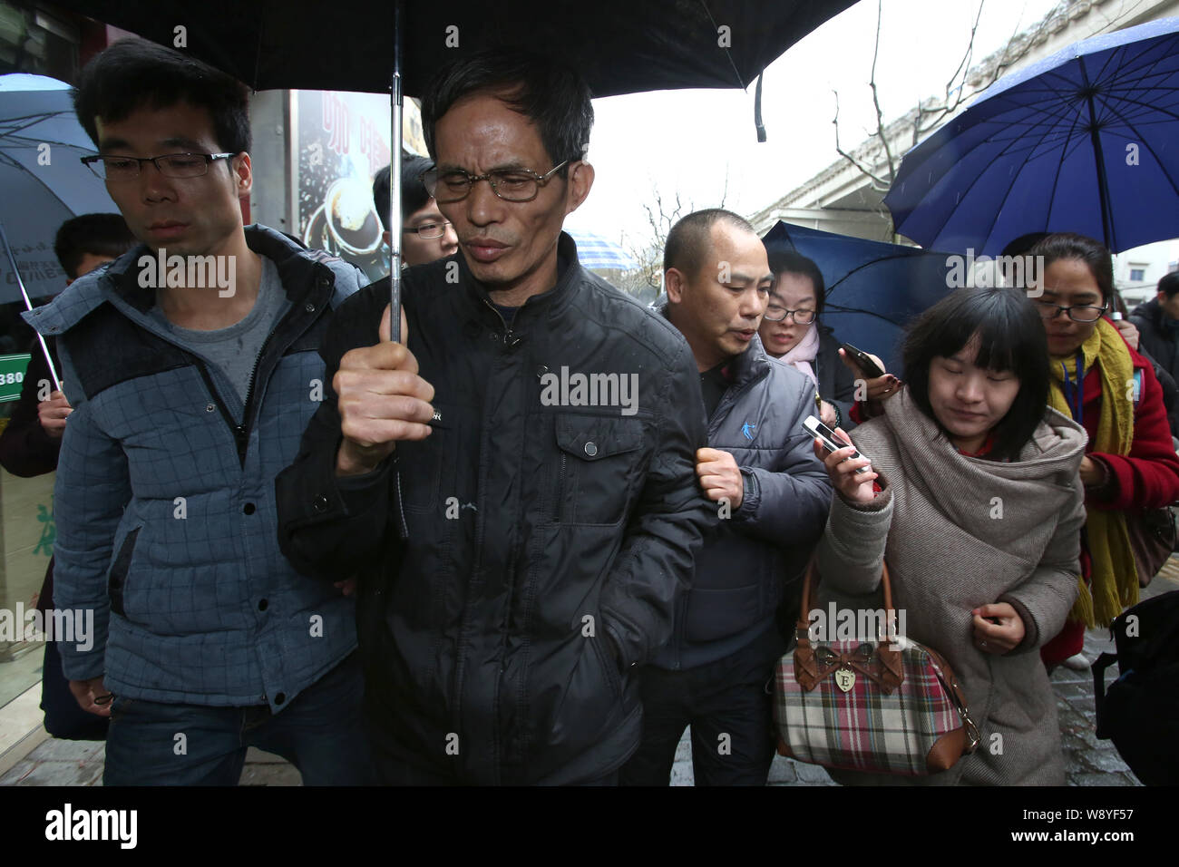 Le vieil homme, dont le fils a été l'empoisonneur dans un cas d'empoisonnement, deuxième à gauche, laisse la cour après avoir entendu la sentence de mort sur son fils au Shanghai Banque D'Images