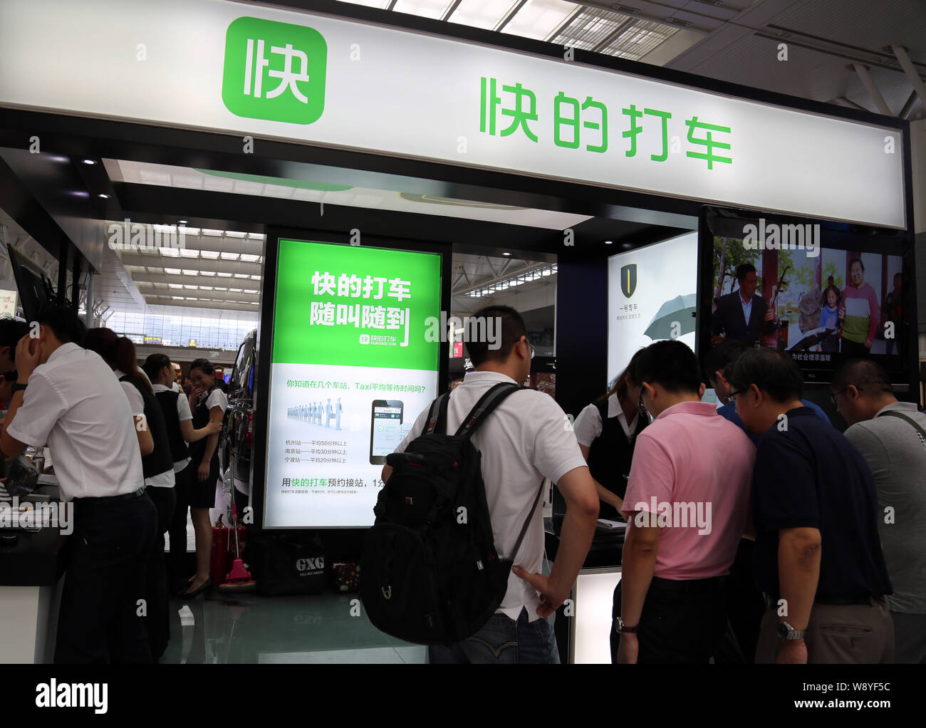 --FILE--personnes visitent le stand de taxi de l'application de réservation de Kuaidi Dache Alibaba lors d'une exposition à Shanghai, Chine, le 24 juillet 2014. Le paiement en ligne Banque D'Images