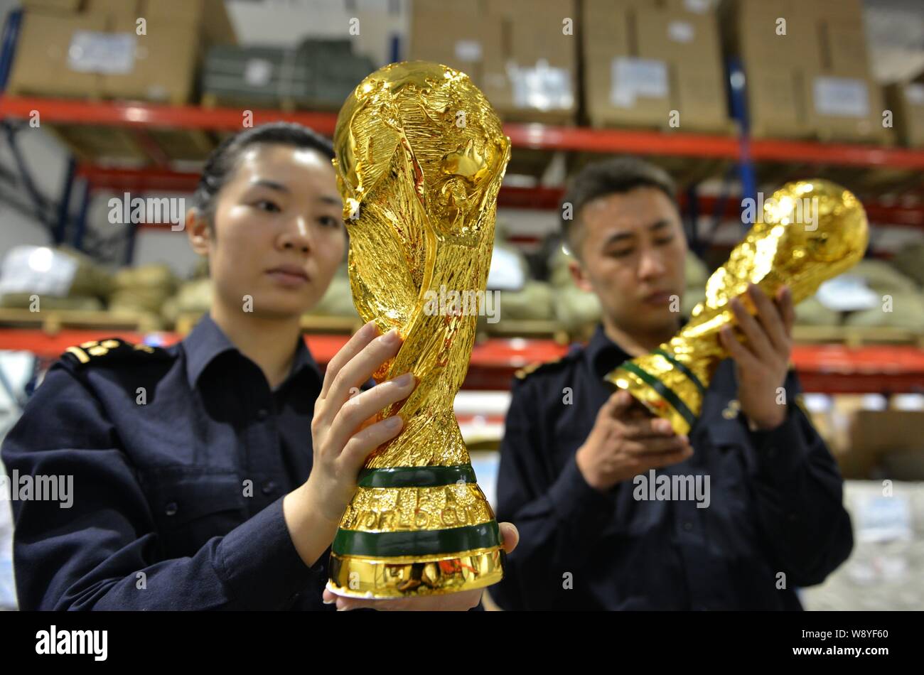 Les agents des douanes chinoises vérifier fake World Cup trophées qu'ils ont saisi dans un entrepôt dans la ville de Yiwu, province de Zhejiang, Chine de l'est le 16 avril 2014. Plus de t Banque D'Images