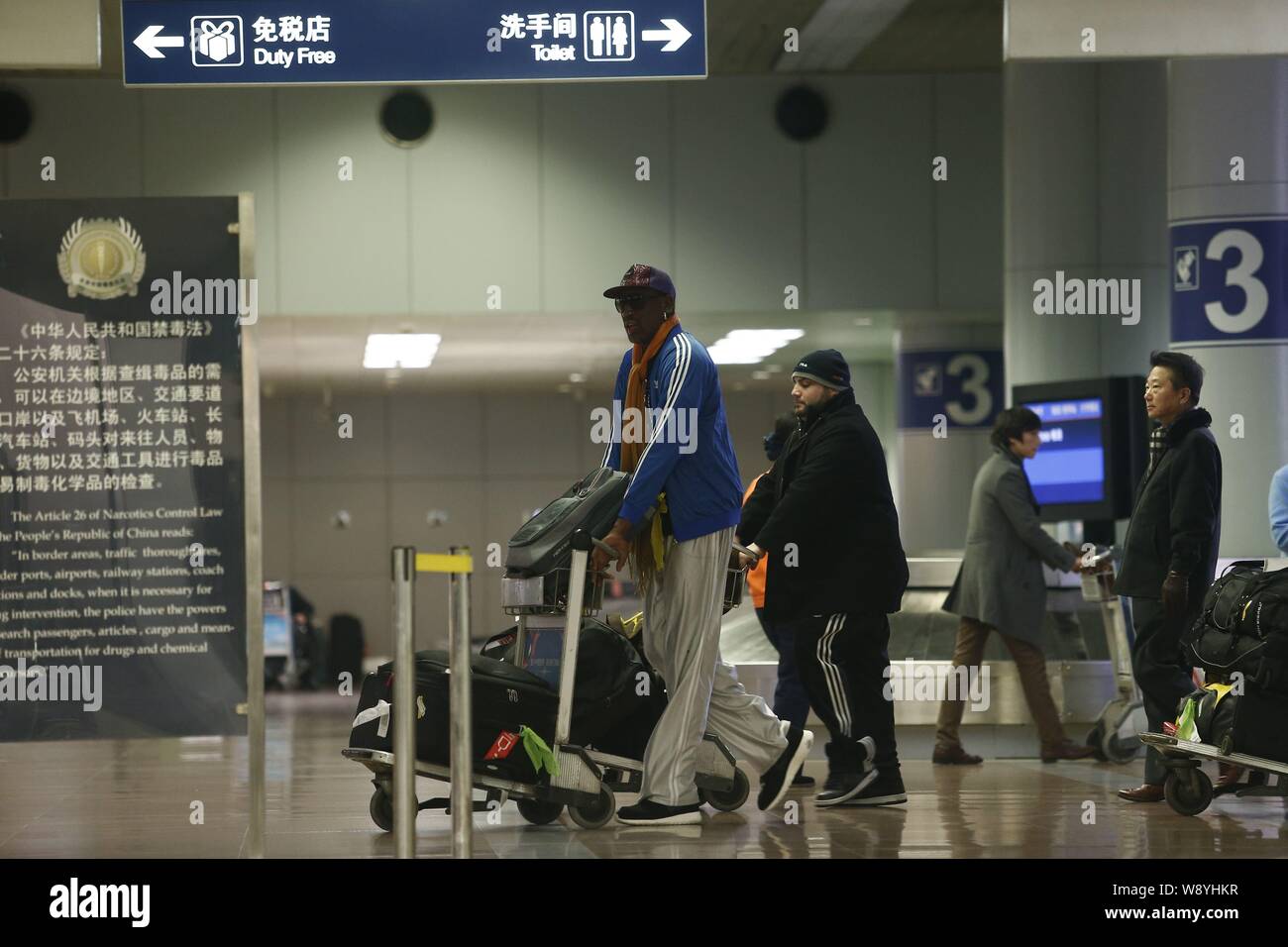 Star de la NBA Dennis Rodman à la retraite, à gauche, pousse un chariot à  bagages après son arrivée à l'aéroport international Beijing Capital de  Pyongyang à Pékin, Chi Photo Stock -