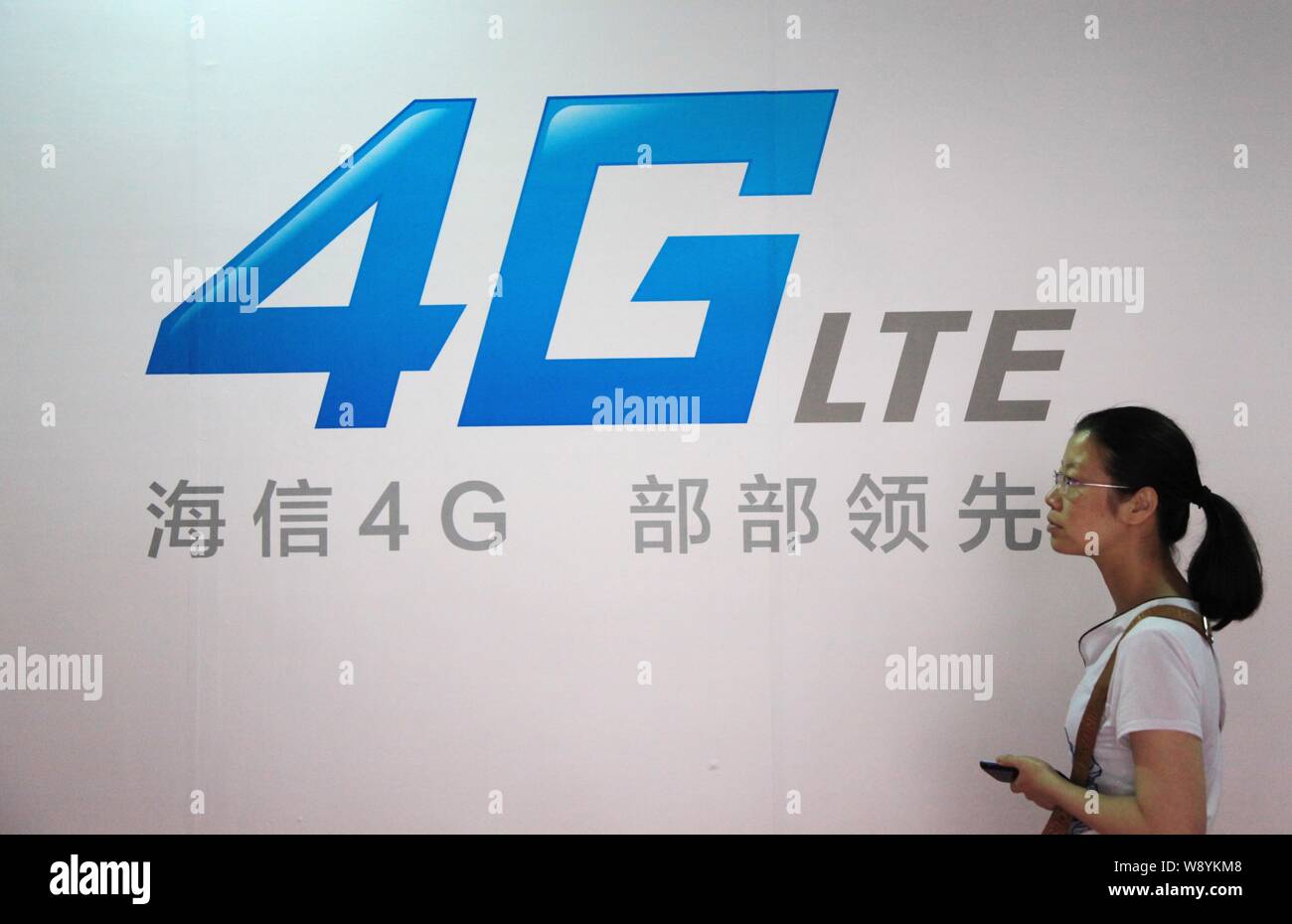 --FILE--un visiteur passe devant une publicité pour Hisense 4G blackberry lors du Tianyi 2014 Juste Mobile et Internet Mobile Forum à Shanghai, e Banque D'Images