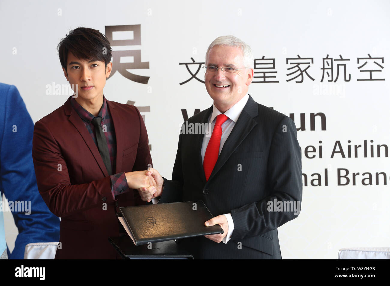Acteur Wu Chun brunéiens, gauche, serre la main avec Royal Brunei Airlines président Dermot Mannion, lors d'une cérémonie de signature pour devenir l'internationa Banque D'Images