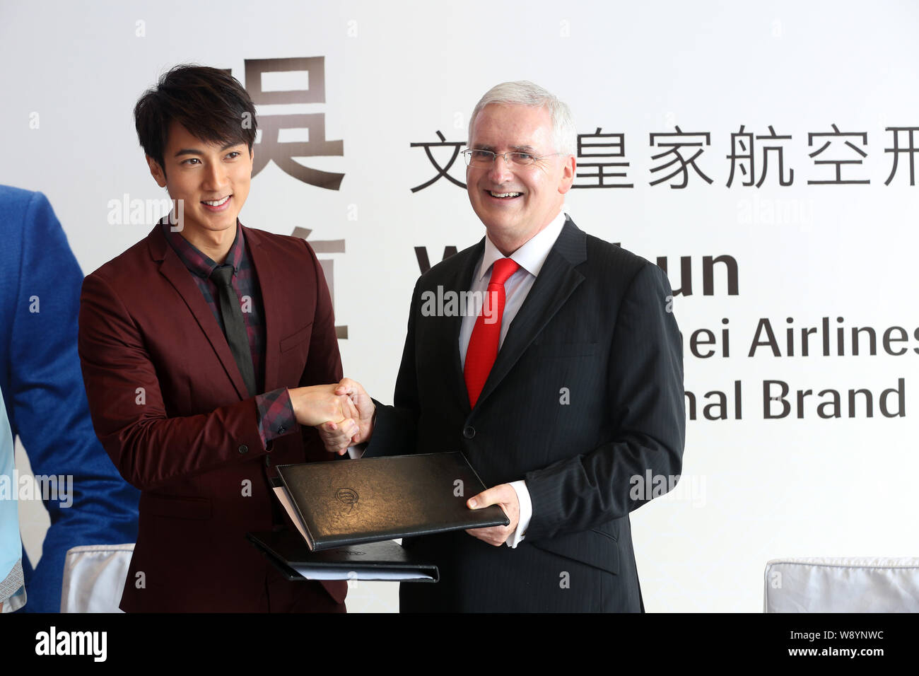 Acteur Wu Chun brunéiens, gauche, serre la main avec Royal Brunei Airlines président Dermot Mannion, lors d'une cérémonie de signature pour devenir l'internationa Banque D'Images
