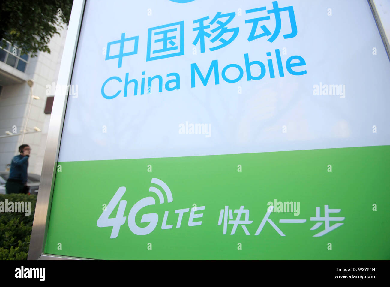 --FILE--un piéton passe devant une publicité pour les réseaux 4G LTE de China Mobile à Shanghai, Chine, 13 mars 2014. China Mobile, China's grandes Banque D'Images