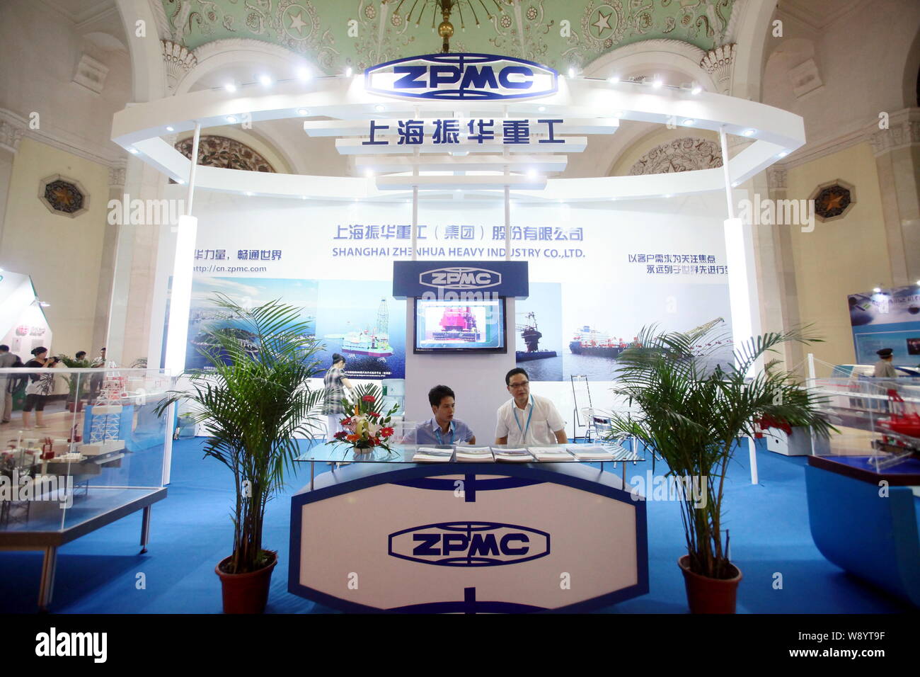 --FILE--Employés sont vus sur le stand de Shanghai Zhenhua Heavy Industry Co., Ltd (ZPMC) lors d'une exposition à Shanghai, Chine, 24 août 2012. Banque D'Images