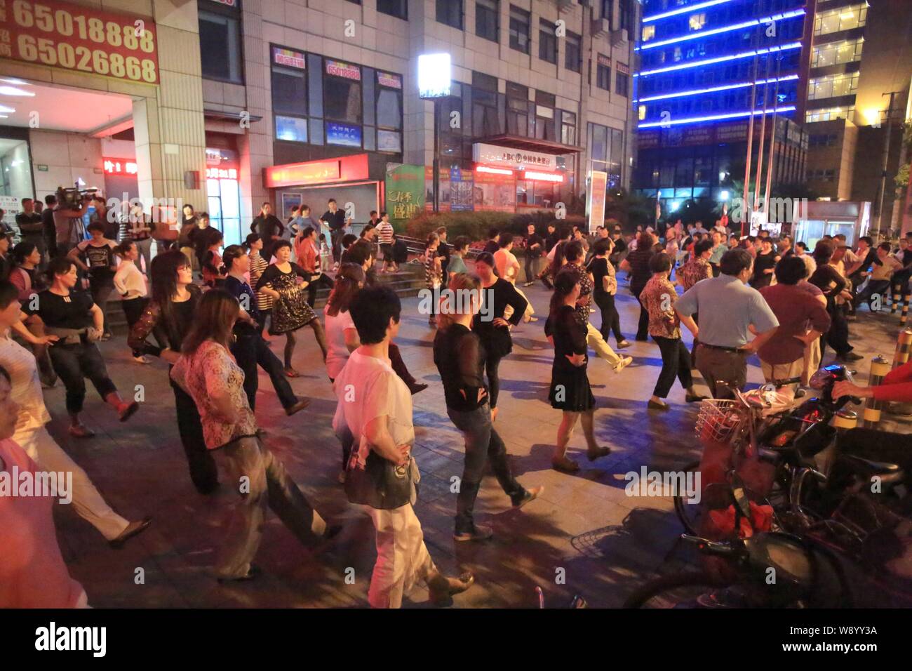 Un groupe de résidents locaux la danse dans un espace ouvert public près de l'entrée no 3 de Quanzhou Road station de métro ligne 8 à Shanghai, Chine, le 4 juin 2014 Banque D'Images