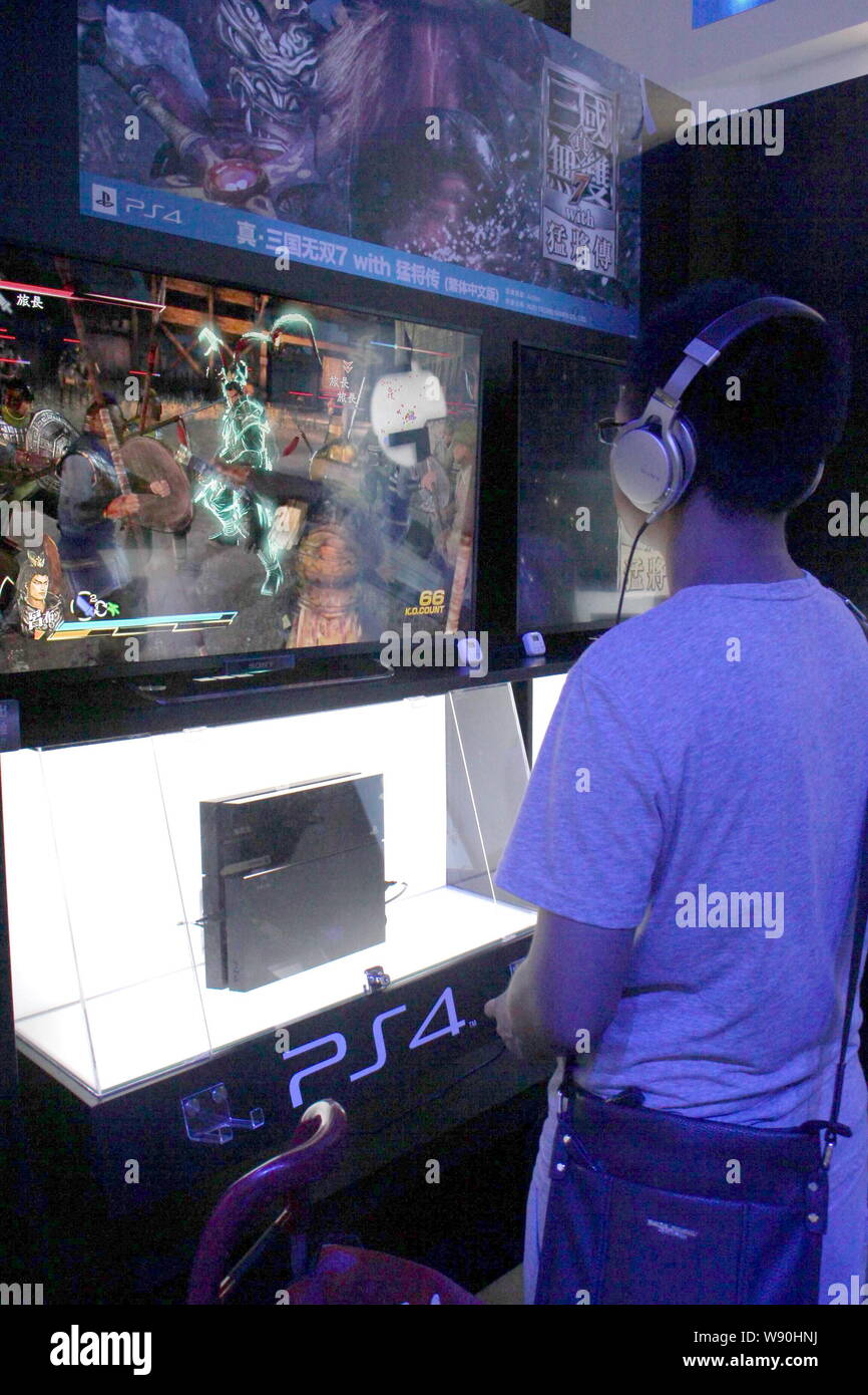 --FILE--un visiteur fait l'essai d'une Sony PlayStation 4 (PS4) console de jeu au cours de la 12e China Digital Entertainment Expo, également connu sous le nom de ChinaJoy 2014, dans Banque D'Images