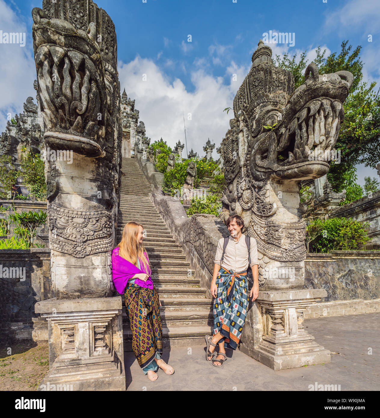 Heureux couple de touristes sur fond de trois échelles de pierre dans le magnifique temple de Lempuyang Luhur Pura. Paysage d'été avec des escaliers à temple Banque D'Images