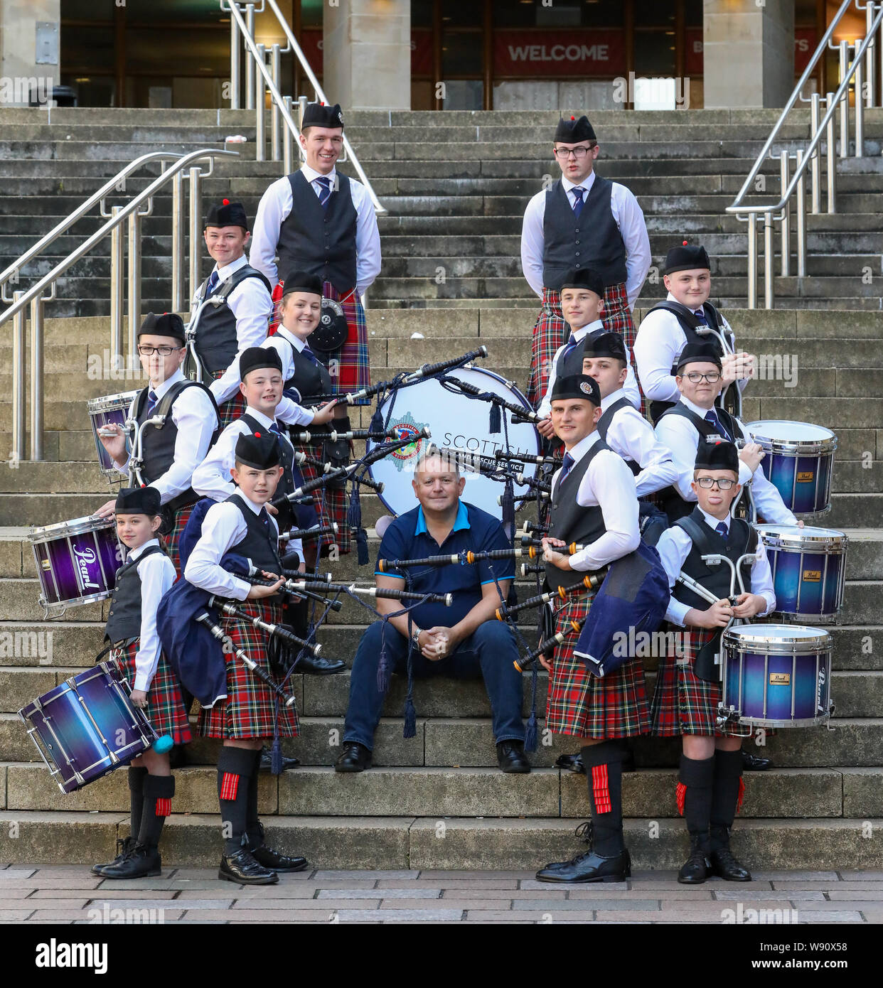 Glasgow, Royaume-Uni. Août 12, 2019. Glasgow international piping festival a fêté aujourd'hui avec une performance spéciale de l'incendie et de sauvetage écossais juvénile Novice Pipe Band. Maintenant dans sa 16e année, le vivre, est le plus grand festival du genre à attirer 40 000 fans de musique, les familles et les fans de partout dans le monde à regarder plus de 5 000 Pipers effectuer à 150 événements dans toute la ville. Image de RODDY MACLEOD, Directeur du Festival avec la bande. Credit : Findlay/Alamy Live News Banque D'Images