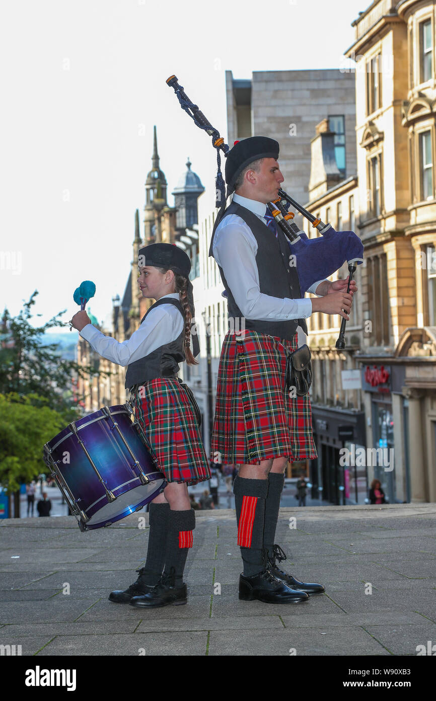 Glasgow, Royaume-Uni. Août 12, 2019. Glasgow international piping festival a fêté aujourd'hui avec une performance spéciale de l'incendie et de sauvetage écossais juvénile Novice Pipe Band. Maintenant dans sa 16e année, le vivre, est le plus grand festival du genre à attirer 40 000 fans de musique, les familles et les fans de partout dans le monde à regarder plus de 5 000 Pipers effectuer à 150 événements dans toute la ville. Photo de EMILY GORMLEY âgés de 11 à la batterie et Gavin Mackenzie âgés de 16 ans sur les tuyaux. Credit : Findlay/Alamy Live News Banque D'Images