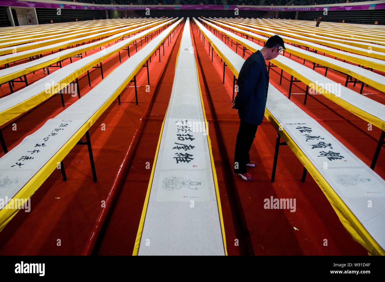 Un homme vues les volutes des sutra bouddhiste écrit par résident chinois il Guojian à un gymnase de basket-ball dans la ville de Shenzhen, Guangdong, Chine du sud pr Banque D'Images