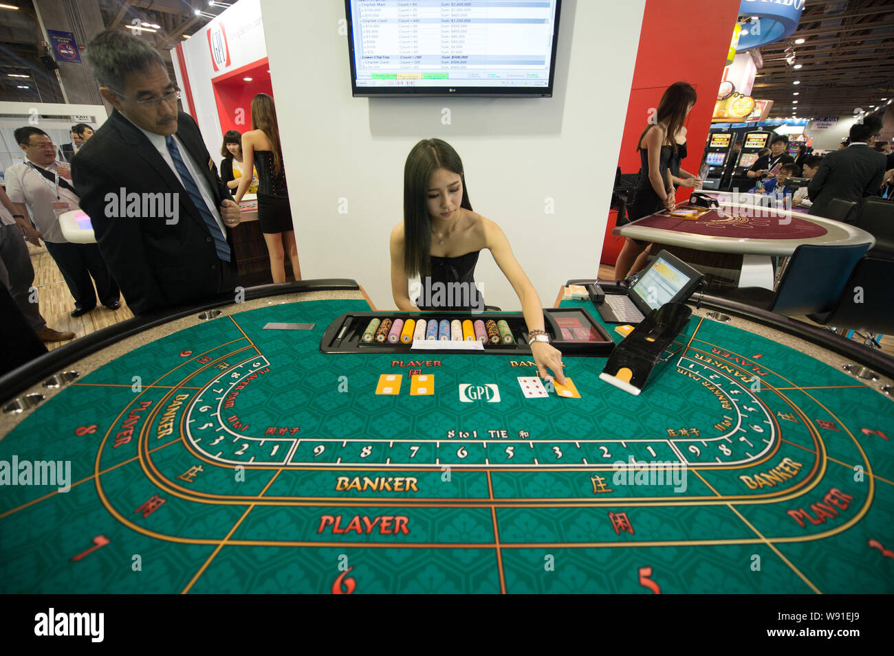 Une jeune femme porte cartes sur une table de jeu au cours de la 7e Global Gaming Expo Asia (G2E Asia 2013) à Macao, Chine, 22 mai 2013. L'industrie de Casino Banque D'Images