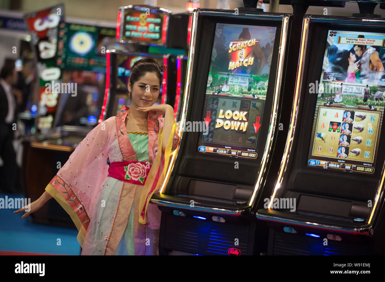 Une showgirl pose avec des machines à sous au cours du 7e salon des Jeux d'Asie (G2E Asia 2013) à Macao, Chine, 22 mai 2013. A rencontré les leaders de l'industrie de Casino Banque D'Images