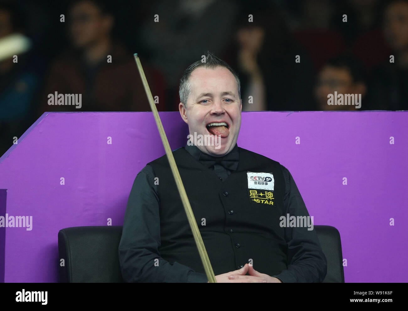 John Higgins, de l'Écosse tire sa langue pendant qu'il observe Joe Swail de l'Irlande du Nord jouer a tourné dans leur premier match du Mondial 2013 Banque D'Images