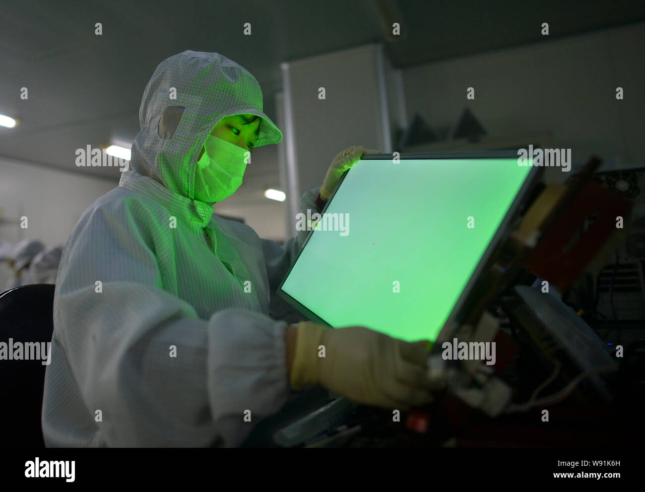 --FILE--Un travailleur chinois examine d''une télévision à écran du panneau de commande à l'usine de Wuhan Hengsheng Optoelectronic Co., Ltd. à Wuhan, Chine centrale Banque D'Images